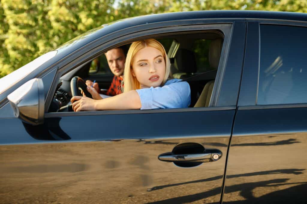 Woman and instructor looking out of the car window